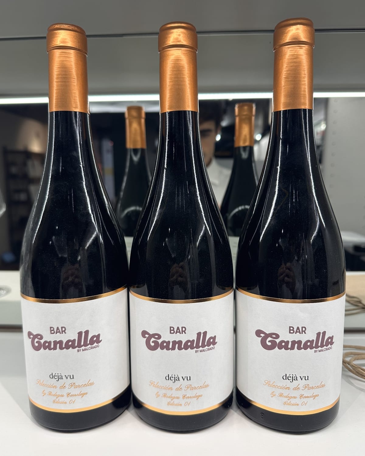 Tres botellas de vino personalizadas con un logotipo en la etiqueta.